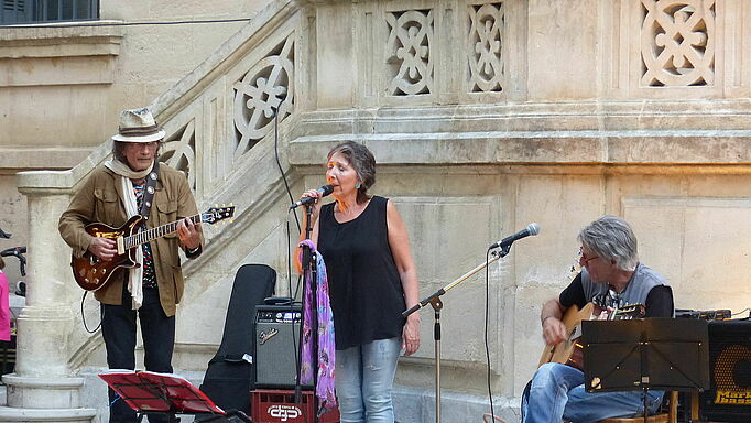 Groupe de musique : trio au pied des escaliers de la mairie.