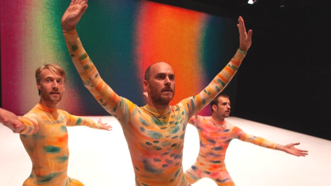 Trois hommes colorés effectuant une danse sur scène